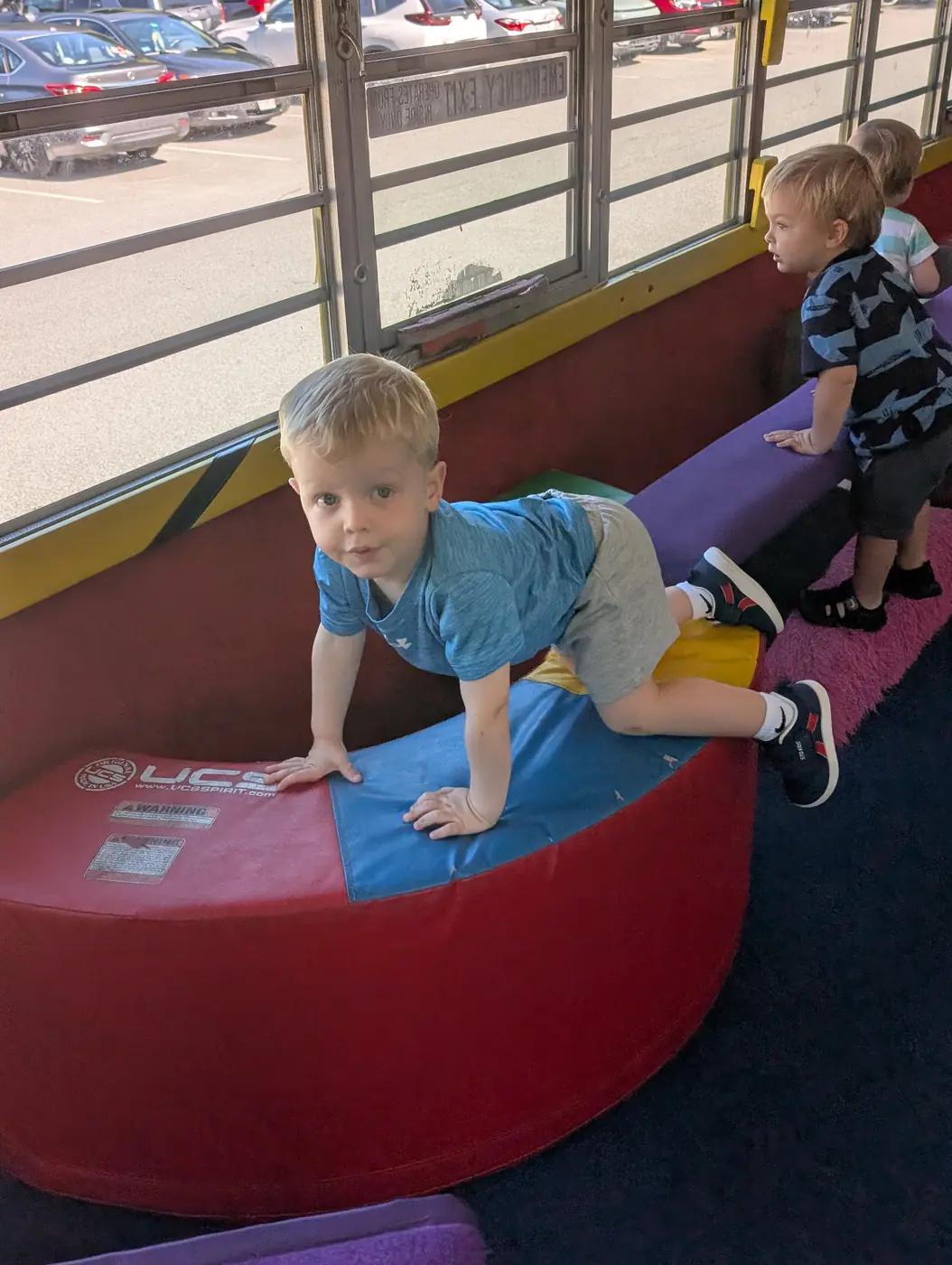 An active toddler climbing and exploring at Blossom Station in Acton, MA
